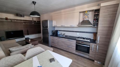 ein Wohnzimmer mit Couch und Küche in der Unterkunft Râșnov Loft in Râșnov
