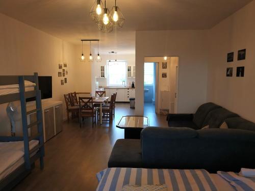 a living room with a couch and a dining room at Apartmán One To One in Štúrovo