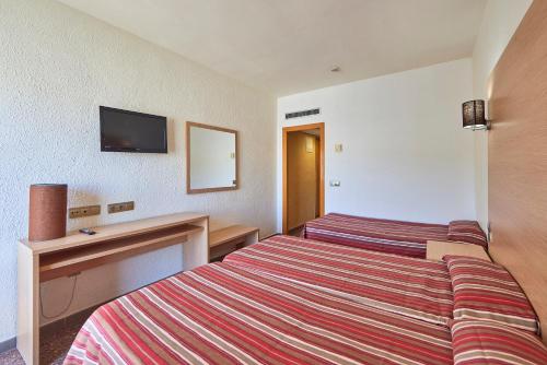 a hotel room with two beds and a television at Ona Don Juan in Lloret de Mar