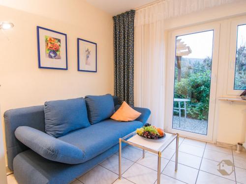 um sofá azul numa sala de estar com uma mesa em Ferienwohnung Christine em Bad Wildbad