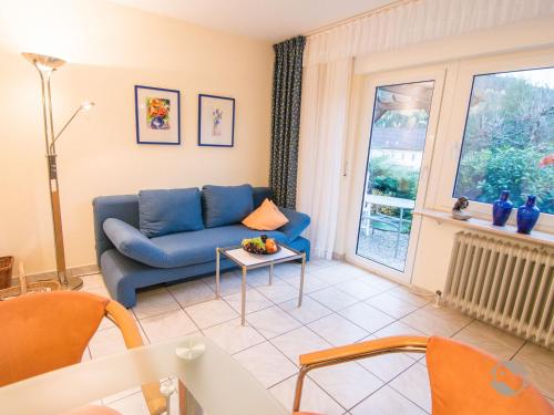 uma sala de estar com um sofá azul e uma janela em Ferienwohnung Christine em Bad Wildbad