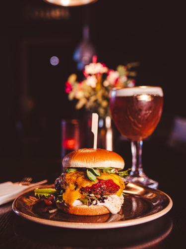 a plate with a sandwich and a glass of wine at Hotel Europa in Aabenraa