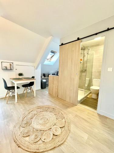 La salle de bains est pourvue d'une douche, d'une table et d'un tapis. dans l'établissement Hyper centre ideal aeroport Beauvais, à Beauvais