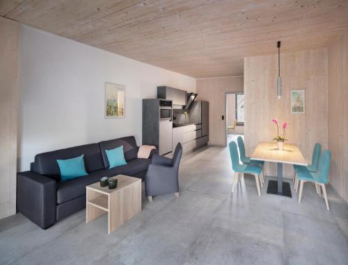 a living room with a couch and a table and chairs at Ferienwohnung im Vogelgesang W3 in Heuchelheim-Klingen