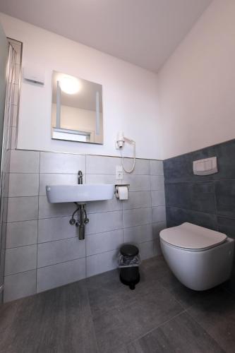 a bathroom with a toilet and a sink at 24/7 selfcheckin Schmiedestrasse in Leer
