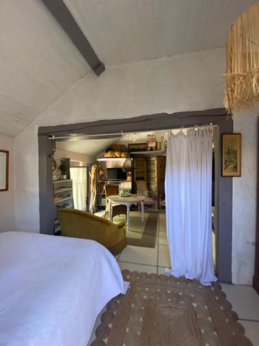 a bedroom with a bed and a living room at La Maison du Bonheur in Thiel-sur-Acolin