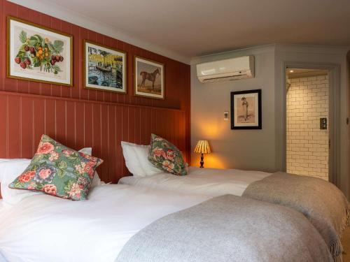 two beds in a hotel room with red walls at Dukes Head Hotel in Croydon