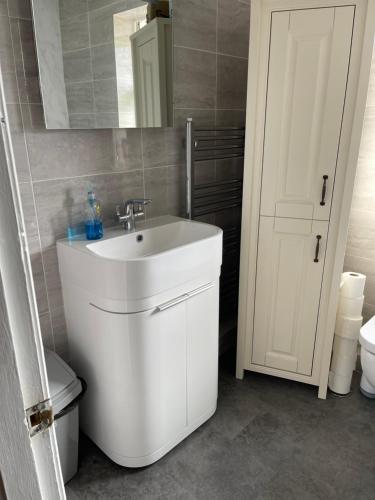 La salle de bains est pourvue d'un lavabo blanc et d'un miroir. dans l'établissement Chateau julie, à Liverpool