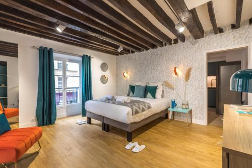 a bedroom with a large bed and a couch at Sweet Inn - Lescot II in Paris
