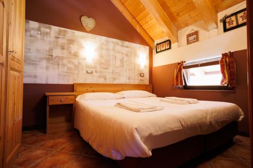 a bedroom with a bed with two towels on it at Residence Stalle Lunghe in Prato Nevoso