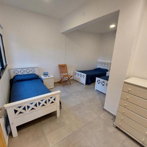 a bedroom with two beds and a chair in it at Finca La Candelaria in Santiago del Estero