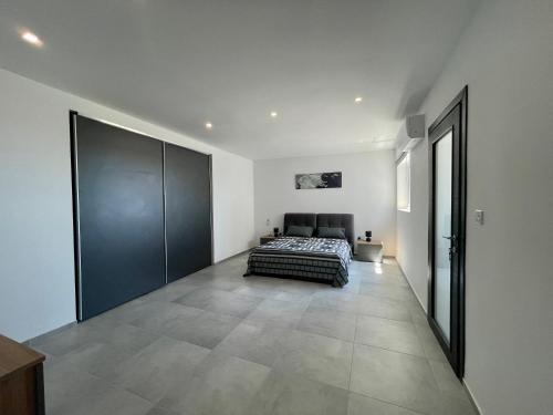 1 dormitorio con 1 cama y puerta corredera grande en 190 Sqm Apartment in Swieqi with Views and free high speed Wifi, en Is-Swieqi