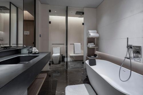 a bathroom with a tub and a sink and a bath tub at Intercontinental Shenzhen Dameisha Resort by IHG in Shenzhen