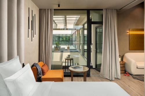 a bedroom with a bed and a living room at The Emporium Hotel Plovdiv - MGallery Collection in Plovdiv
