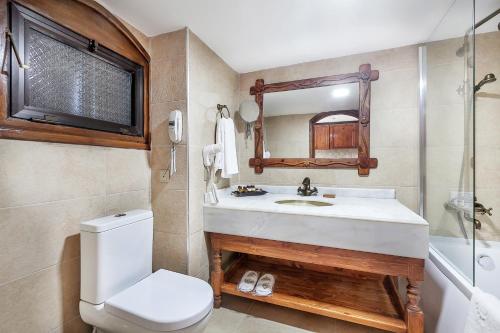 a bathroom with a sink and a toilet and a mirror at Le Chateau Lambousa in Kérynia