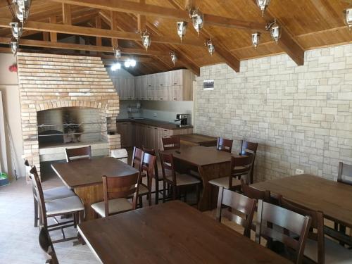 un restaurante con mesas y sillas de madera y una pared de ladrillo en Вила Христови en Bŭlgarevo