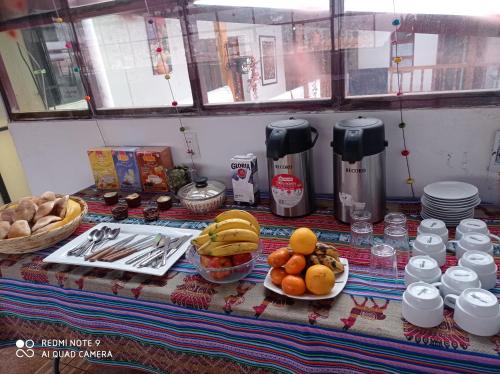 einen Tisch mit Teller mit Lebensmitteln auf einem Tisch in der Unterkunft Hostel mágico San Blas in Cusco