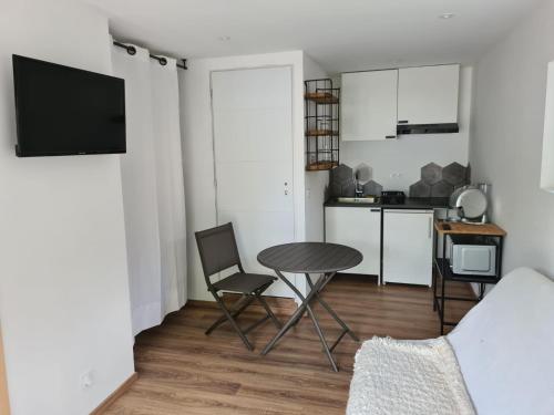 salon ze stołem i krzesłami oraz kuchnia w obiekcie Studio neuf à Barcelonnette w mieście Barcelonnette