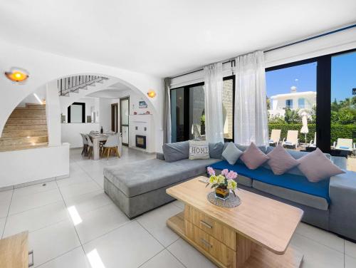 a living room with a blue couch and a table at Kymma Villa #16 in Ayia Napa