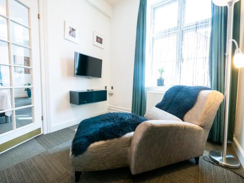 a living room with a couch and a tv and a window at Hotel Europa in Aabenraa