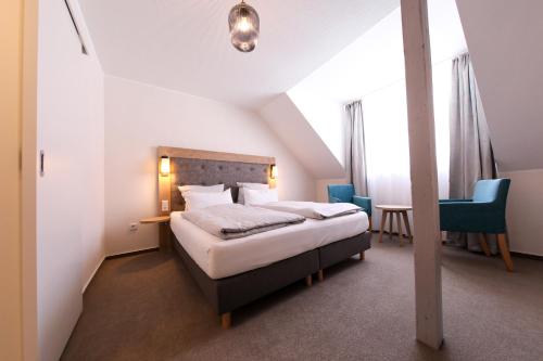 a hotel room with a bed and a table and chairs at 24/7 selfcheckin Schmiedestrasse in Leer