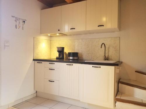 eine Küche mit weißen Schränken und einem Waschbecken in der Unterkunft Le '47' Village de Campagne, 83310 Cogolin in Cogolin