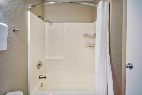 a bathroom with a shower with a white shower curtain at Motel 6-Vallejo, CA - Six Flags West in Vallejo