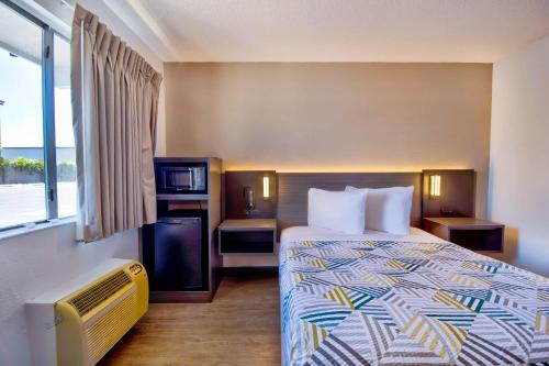 a hotel room with a bed and a tv at Motel 6-Vallejo, CA - Six Flags West in Vallejo