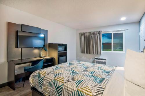 a bedroom with a bed and a desk with a television at Motel 6-Vallejo, CA - Six Flags West in Vallejo