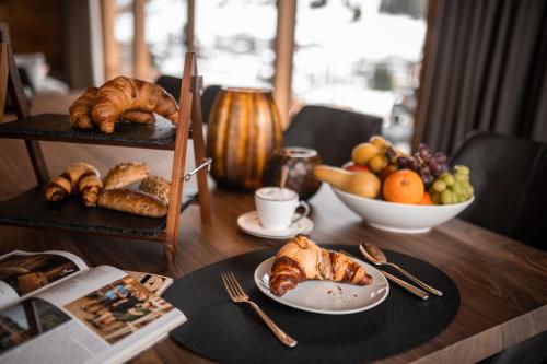 a table with croissants and a plate of bread and fruit at Arla Luxury Home in Lech am Arlberg