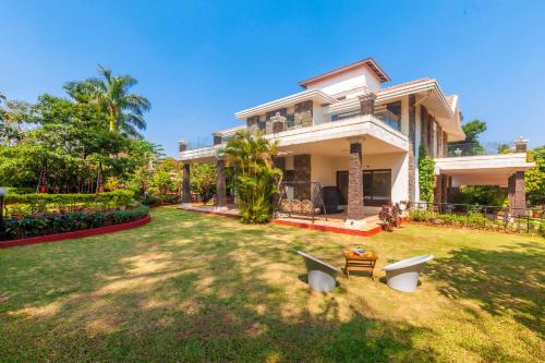 a house with a large yard in front of it at StayVista's Valencia Villa with Gazebo and Indoor Games in Lonavala