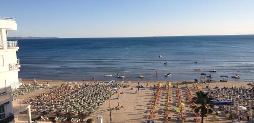 a beach with a lot of umbrellas and the ocean at Vila Tirona in Durrës