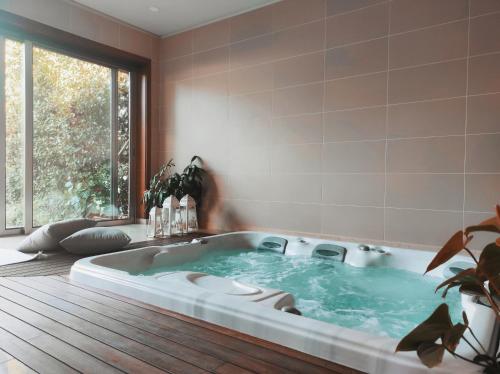 bañera de hidromasaje en una habitación con ventana grande en Countryside Villa near Porto, en Paredes