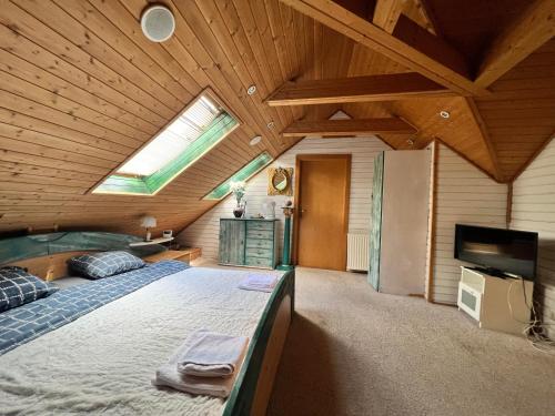 ein großes Schlafzimmer mit einem großen Bett und einem Dachfenster in der Unterkunft B&B Chardas in Bük