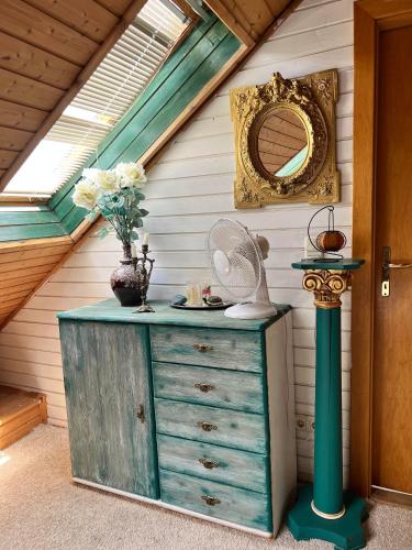 a dresser with a fan on top of it with a mirror at B&B Chardas in Bük