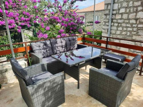 a patio with a table and chairs and flowers at Old town rooms in Rab