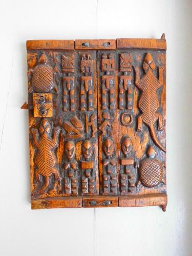 an old wooden box with people on a wall at Hotel Kavana in Ouagadougou