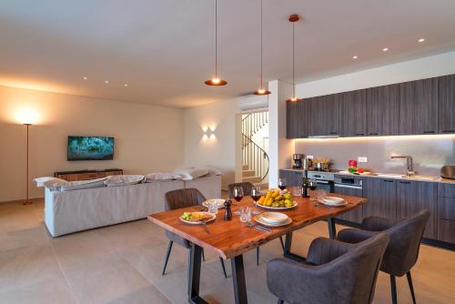 a kitchen and a living room with a table and chairs at Aethrion Villas & Suites in Gennadi