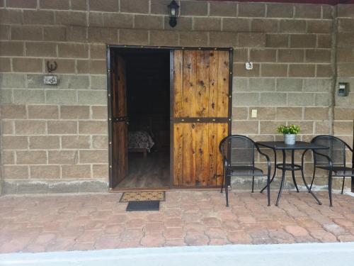 a patio with a table and chairs and a wooden door at Finca Los Angeles Hospederia & Sociales in Huasca de Ocampo