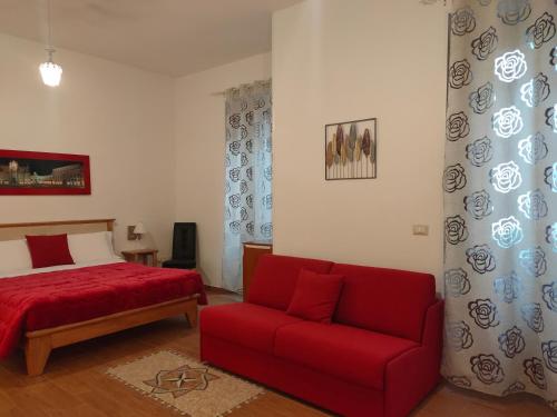 a bedroom with a red bed and a red couch at Family House in Lecce
