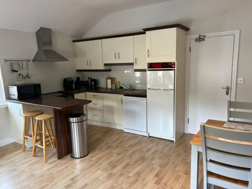 cocina con electrodomésticos blancos y suelo de madera en Loughrea Lodge Kilrush County Clare V15 NX53 en Kilrush