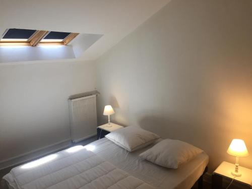 um quarto com uma cama branca e 2 candeeiros em Victor Hugo 4 G et sa pizza offerte em Aurillac