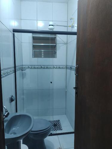 a bathroom with a shower and a toilet and a sink at Pousada Brilho do Sol in Guarujá
