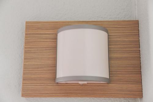 a white object on a wooden shelf on a wall at Premiere Classe Lyon Beynost in Beynost