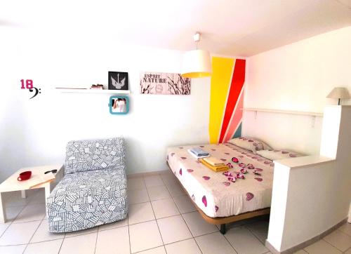 een kleine slaapkamer met een bed en een stoel bij COZY STUDIO, WIFI FREE POOL VIEW in Playa de las Americas