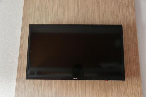 a flat screen tv hanging on a wall at Premiere Classe Lyon Beynost in Beynost