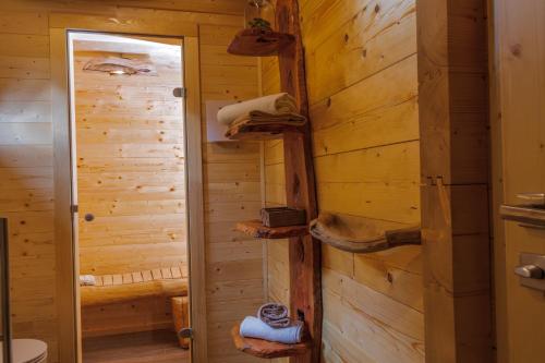 a log cabin bathroom with a wooden wall at Lake Cottage - Koča ob jezeru in Nazarje