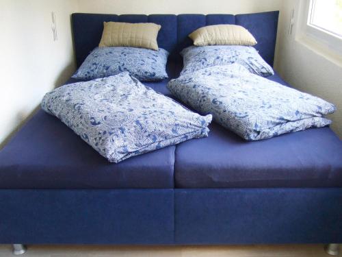 a blue couch with two pillows on it at Ferienwohnung am See in Wochowsee