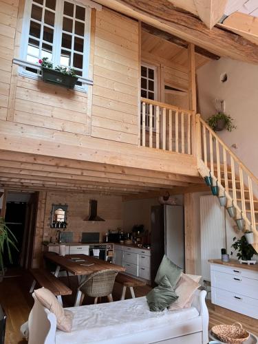 ein Holzhaus mit einer Treppe im Wohnzimmer in der Unterkunft Gites Graines du Jura in Chille