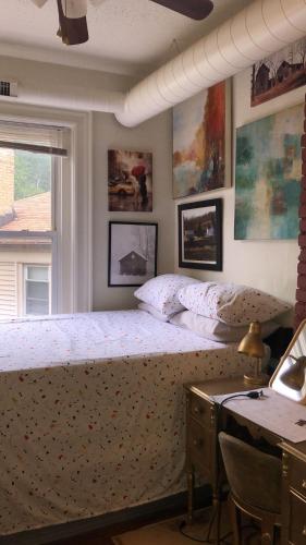 a bedroom with a bed and a desk and a window at Highland Park Pittsburgh in Pittsburgh